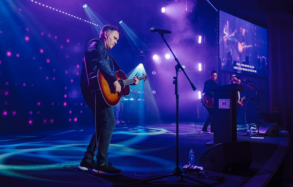 A worship band performs on stage at Harvest Church.