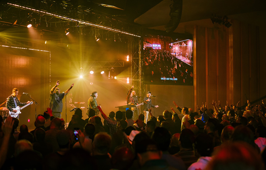 During a worship service, a worship band performs at Harvest Church.
